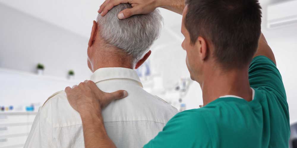 A chiropractor discusses treatment with patient.