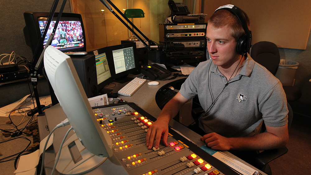 A communication studies major uses the television studio.