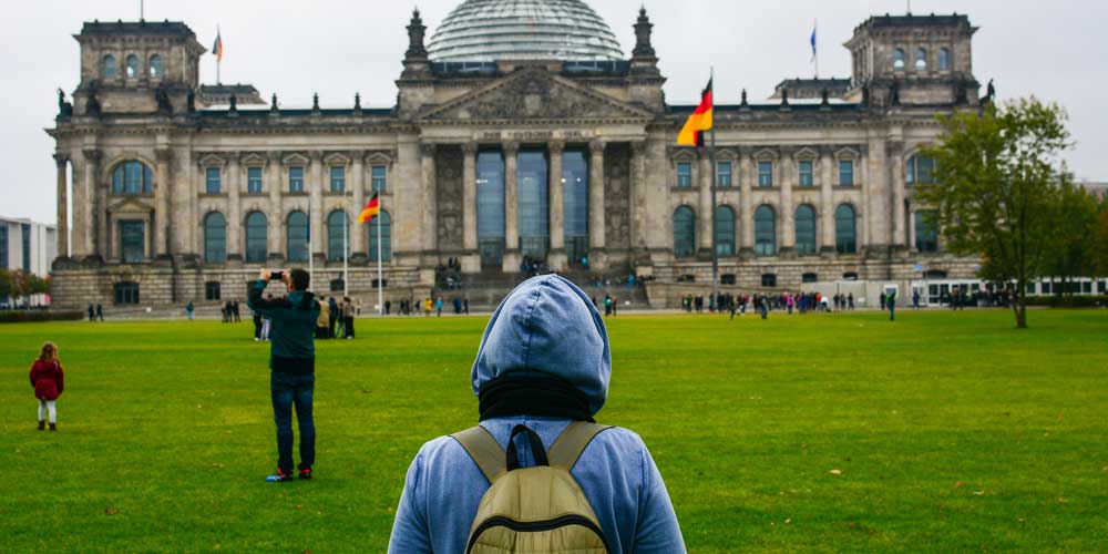 A student walks toward German building in a study abroad program.
