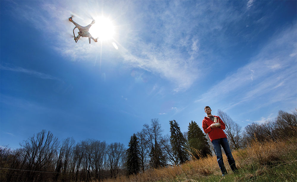 Aaron Haegele controls a flying drone.